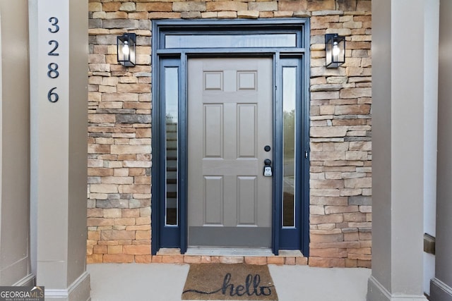 property entrance with stone siding and brick siding