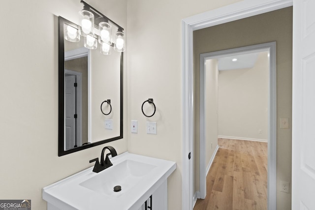 bathroom featuring baseboards, wood finished floors, and vanity