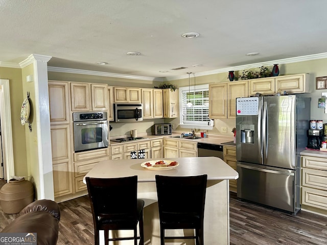 kitchen with appliances with stainless steel finishes, a kitchen island, dark hardwood / wood-style floors, and sink