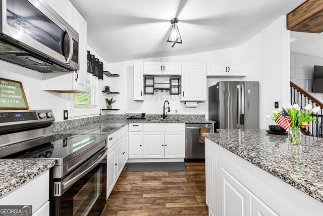 kitchen featuring white cabinets, stainless steel appliances, sink, lofted ceiling, and dark hardwood / wood-style floors