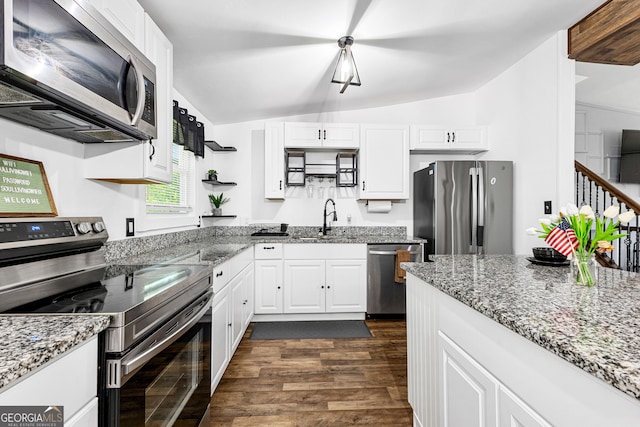 kitchen featuring a sink, vaulted ceiling, appliances with stainless steel finishes, white cabinetry, and dark wood-style flooring