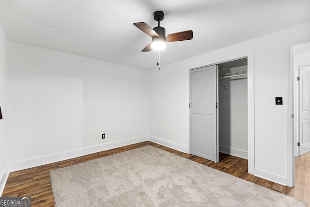 unfurnished bedroom with wood finished floors, baseboards, and a closet