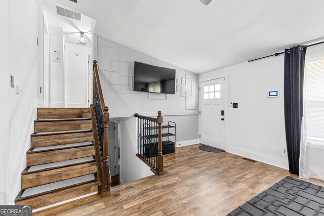 foyer featuring lofted ceiling, hardwood / wood-style flooring, and ceiling fan