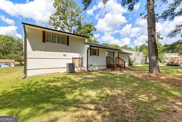 rear view of property with a yard and cooling unit