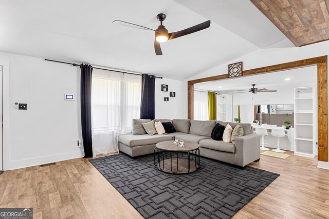 living room featuring vaulted ceiling, hardwood / wood-style flooring, and ceiling fan