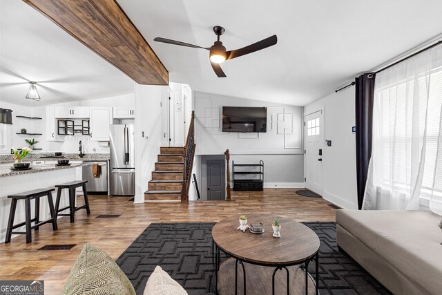 living room featuring lofted ceiling, wood-type flooring, and ceiling fan