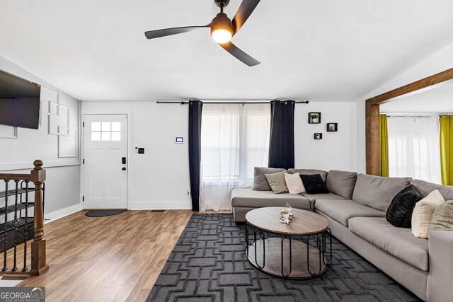 living room with ceiling fan, a wealth of natural light, and dark hardwood / wood-style floors