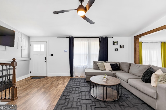 living room with light wood-style flooring, baseboards, lofted ceiling, and ceiling fan