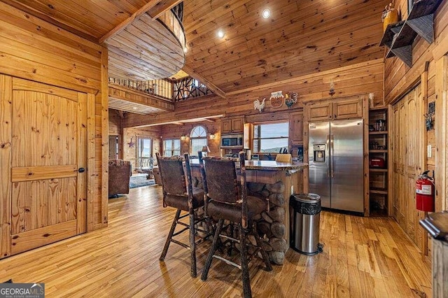 kitchen with appliances with stainless steel finishes, high vaulted ceiling, and a wealth of natural light