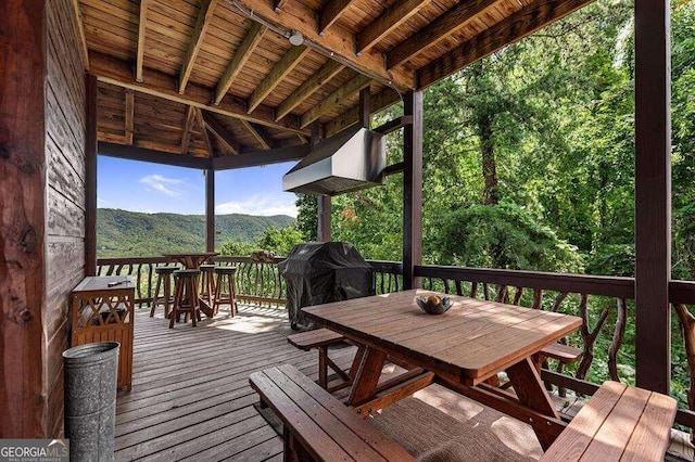 wooden deck with a mountain view and a grill