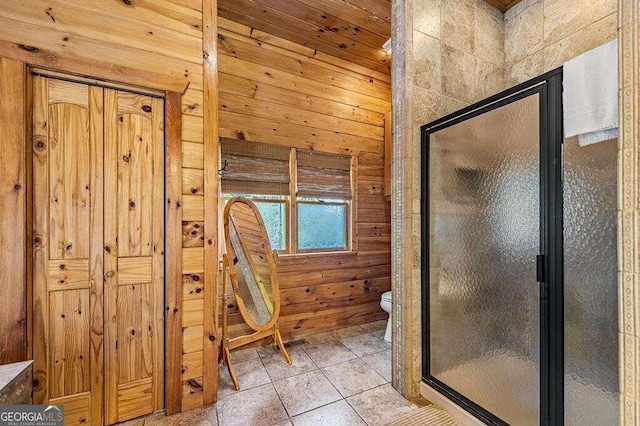 bathroom with toilet, an enclosed shower, wood walls, and tile patterned flooring