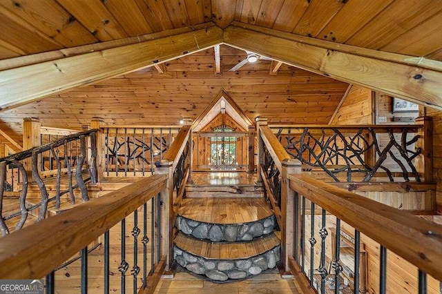 stairway featuring wooden ceiling, lofted ceiling, wooden walls, and hardwood / wood-style floors