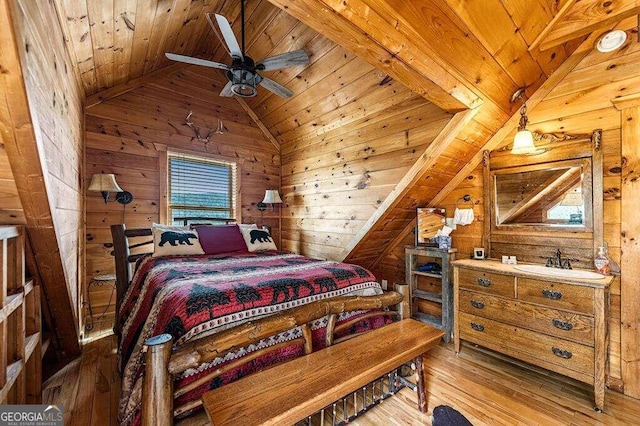 bedroom with lofted ceiling, wooden walls, wood-type flooring, sink, and ceiling fan