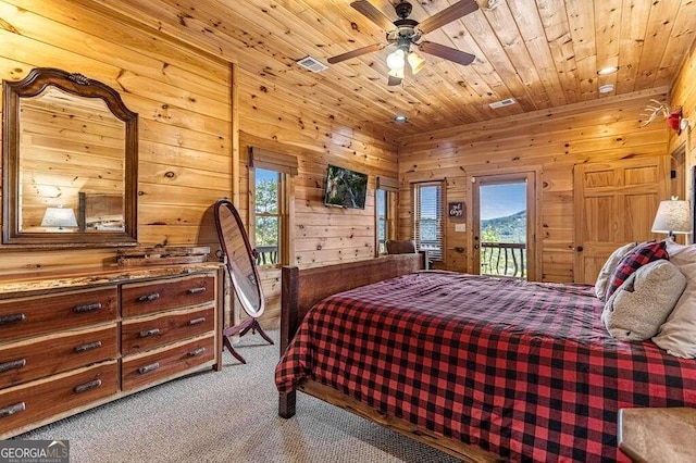 carpeted bedroom with ceiling fan, wood walls, wooden ceiling, and access to exterior