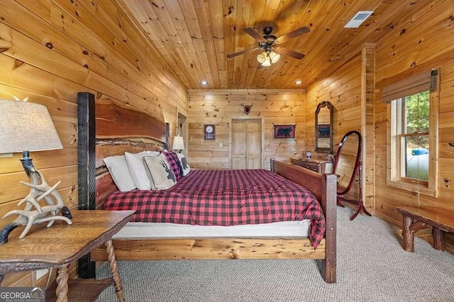 bedroom featuring carpet floors, wooden walls, wooden ceiling, and ceiling fan