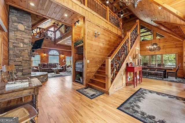 stairs featuring high vaulted ceiling, plenty of natural light, and hardwood / wood-style floors