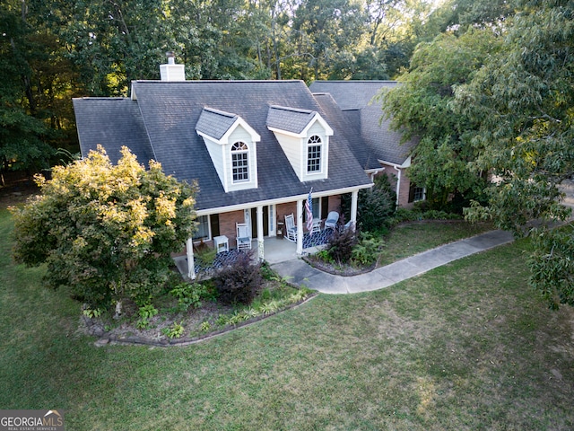 cape cod house featuring a porch and a front lawn