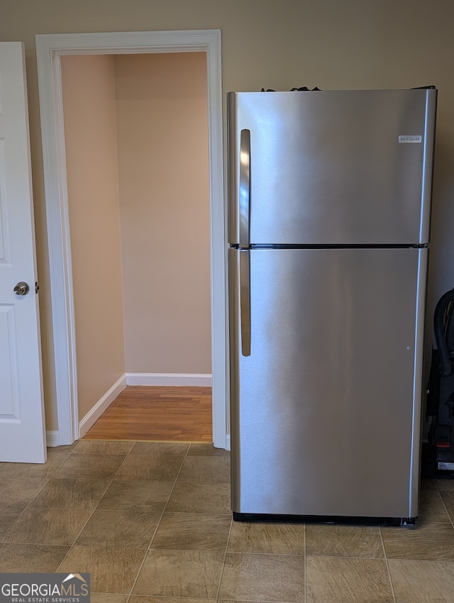 kitchen with hardwood / wood-style flooring and stainless steel refrigerator