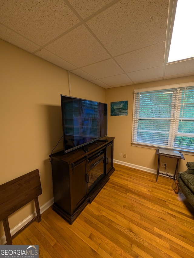 living room featuring a paneled ceiling and light hardwood / wood-style floors