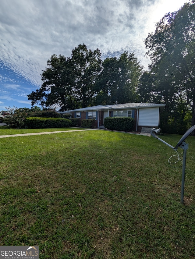 single story home featuring a garage and a front lawn