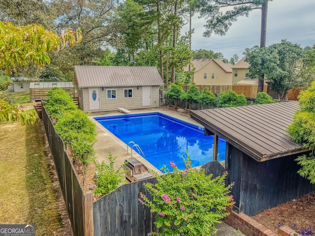 view of swimming pool featuring an outdoor structure and a diving board