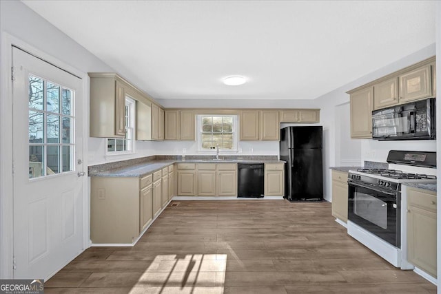 kitchen with sink, black appliances, and light hardwood / wood-style floors