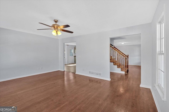 unfurnished living room with ceiling fan and dark hardwood / wood-style flooring