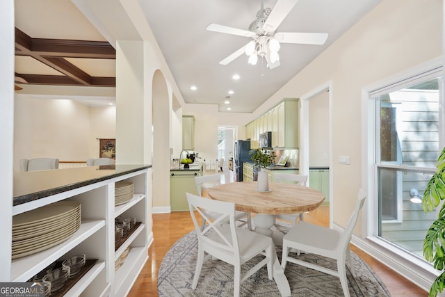 dining space featuring coffered ceiling, beam ceiling, ceiling fan, and light hardwood / wood-style floors