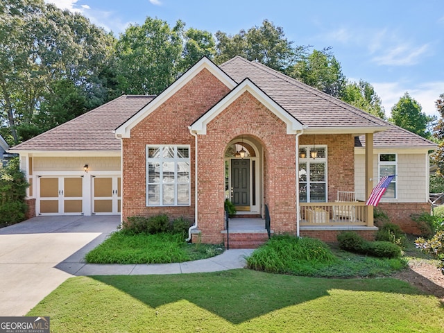 view of front of home with a garage, a front yard, and covered porch