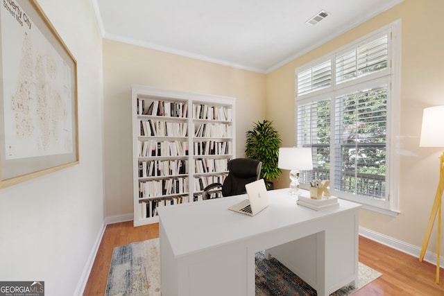 office area with crown molding and light hardwood / wood-style floors