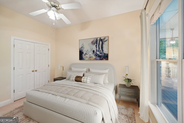 carpeted bedroom with ceiling fan and a closet