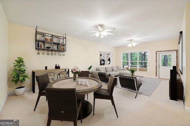 carpeted dining space with ceiling fan