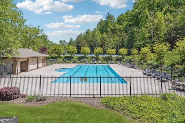 view of pool with a patio area and a yard