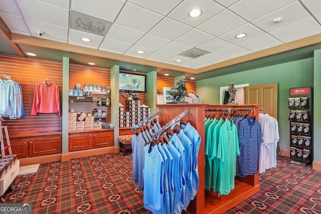 interior space featuring carpet flooring and a drop ceiling