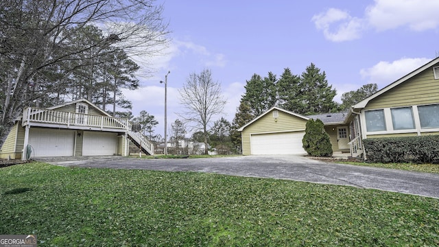 exterior space featuring driveway, a garage, and a yard