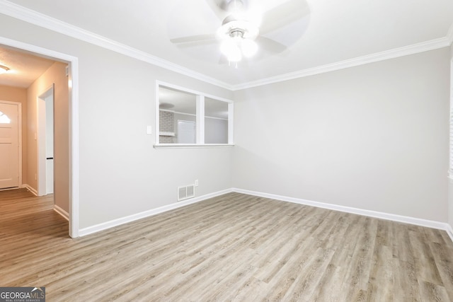 spare room featuring visible vents, ornamental molding, baseboards, and wood finished floors