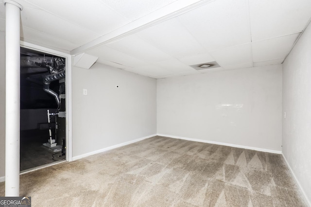 spare room with a paneled ceiling, baseboards, and carpet floors