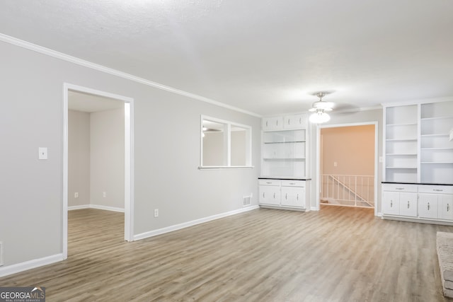 unfurnished living room featuring ceiling fan, crown molding, and wood-type flooring