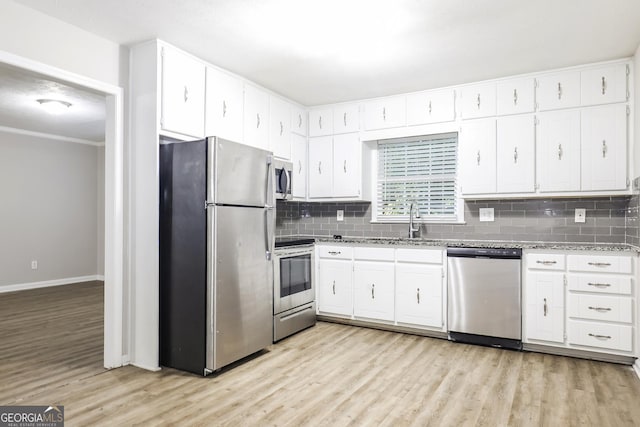 kitchen featuring tasteful backsplash, light wood-style flooring, appliances with stainless steel finishes, and white cabinets