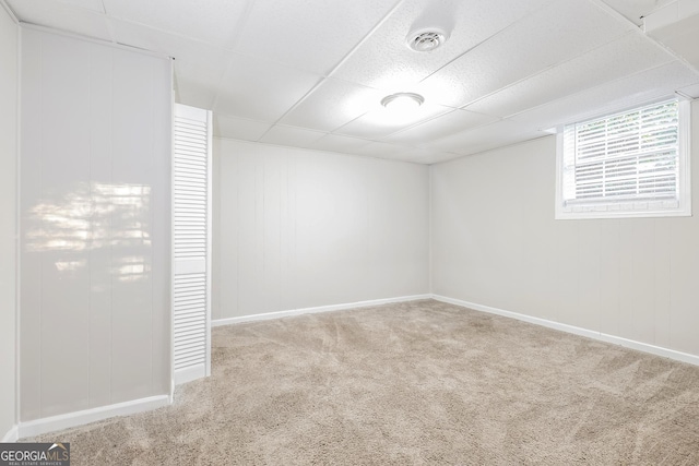 unfurnished room featuring visible vents, baseboards, a paneled ceiling, and carpet