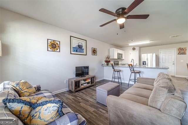 living room with dark wood-type flooring and ceiling fan