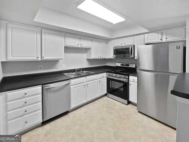 kitchen featuring stainless steel appliances, a sink, and dark countertops