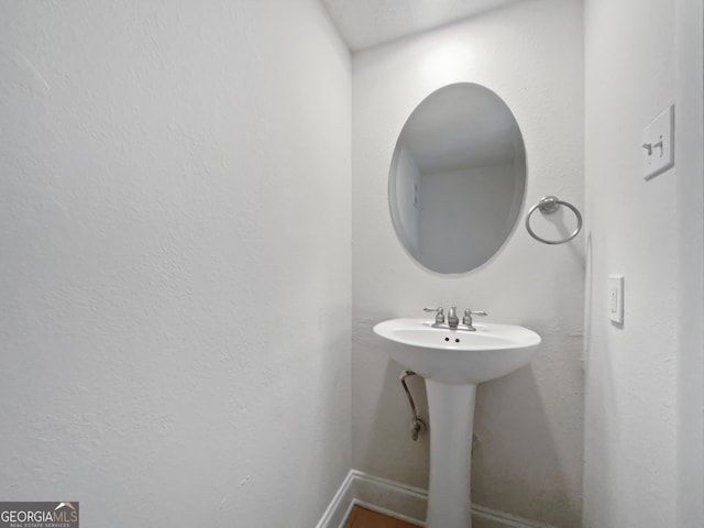 bathroom featuring baseboards and a sink