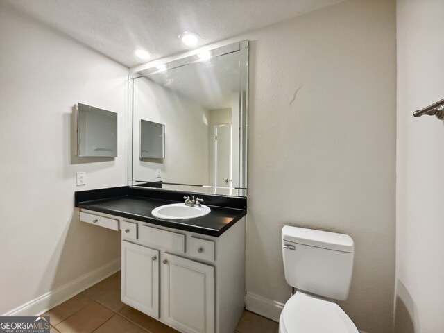 bathroom with vanity, toilet, and tile patterned floors