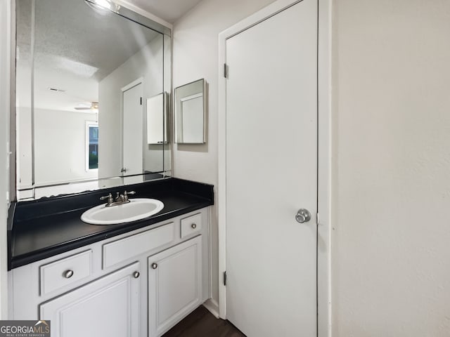 bathroom with vanity, a textured ceiling, hardwood / wood-style flooring, and ceiling fan