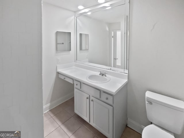 bathroom with baseboards, tile patterned flooring, vanity, and toilet