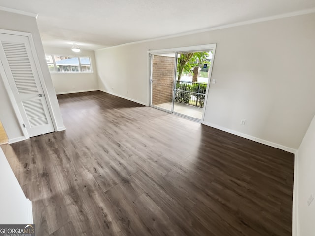 unfurnished room featuring ornamental molding and dark hardwood / wood-style flooring