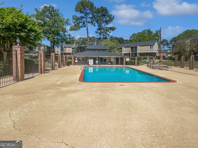 community pool featuring fence and a patio area