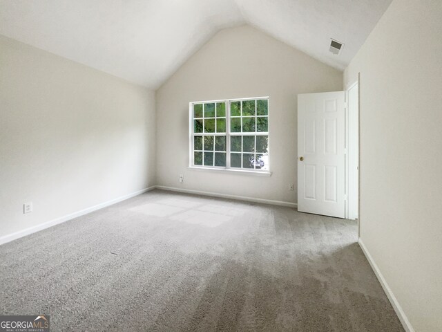 empty room featuring lofted ceiling and light colored carpet