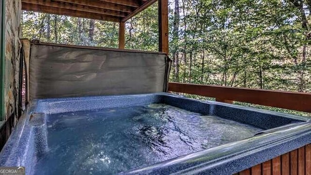 view of swimming pool with a hot tub